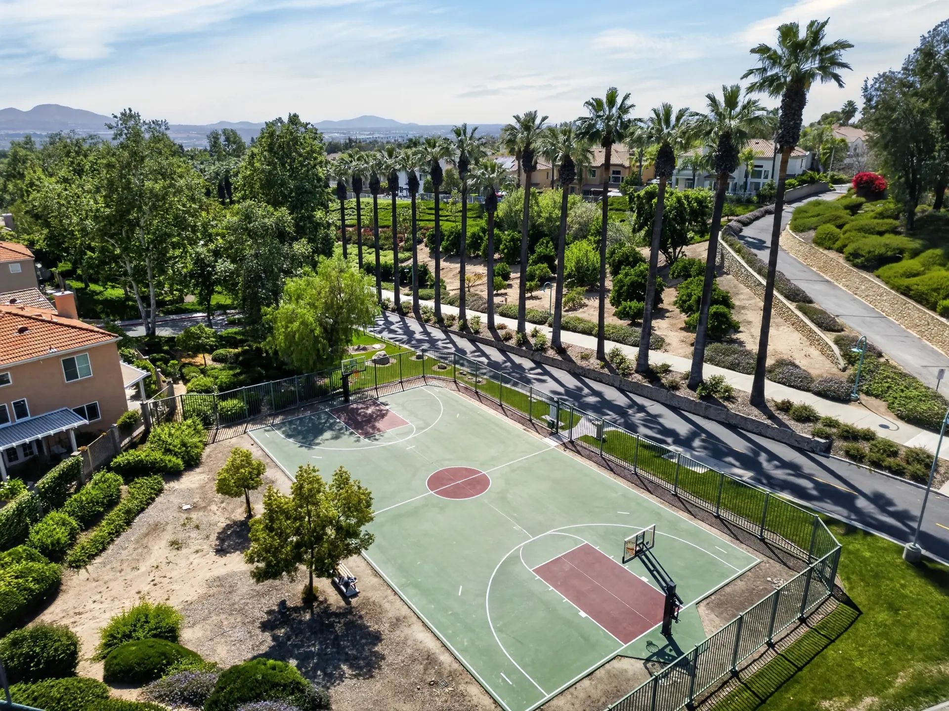 Aerial drone photo of community basketball court with palm trees
