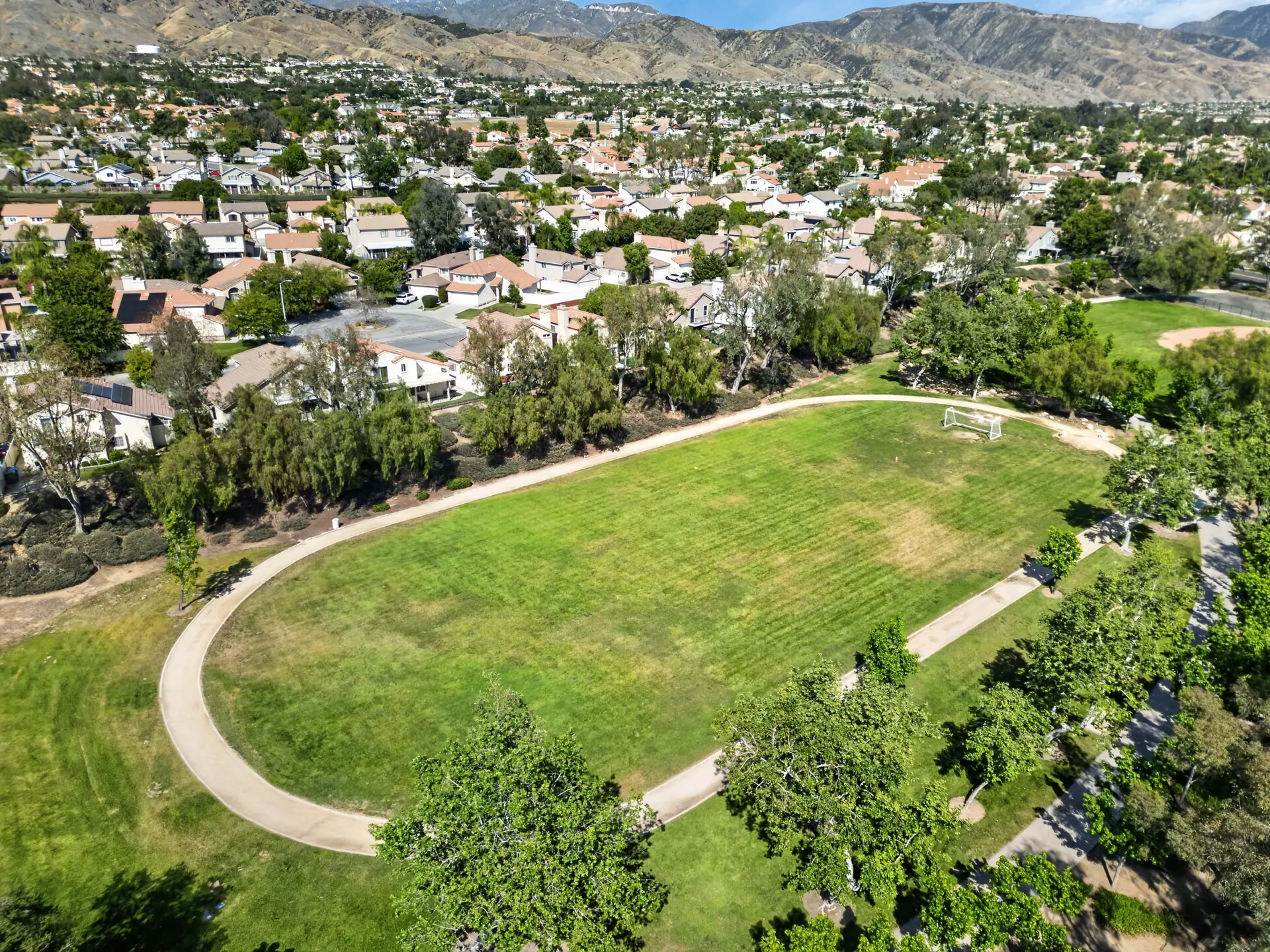 Aerial drone photo of community soccer field and track with mountain backdrop