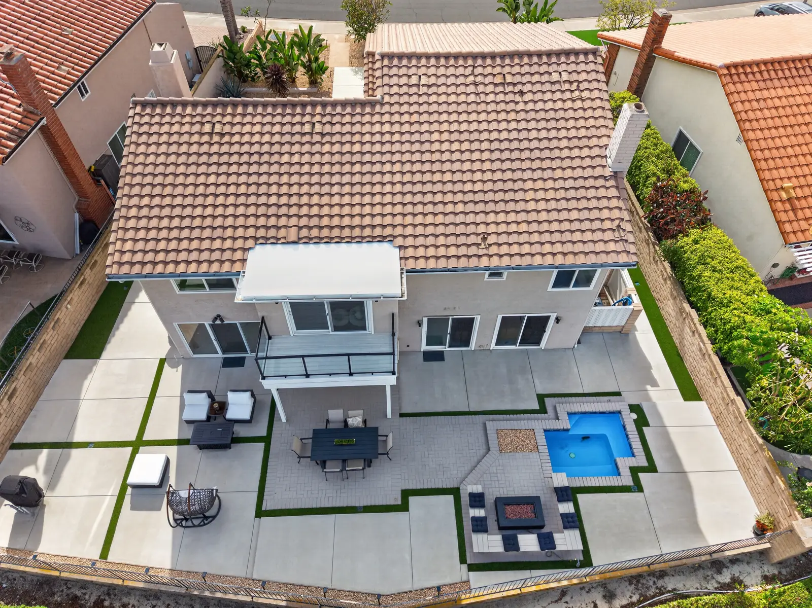 Drone overhead aerial of same backyard showing pool, fire pit, patio layout, and lot size